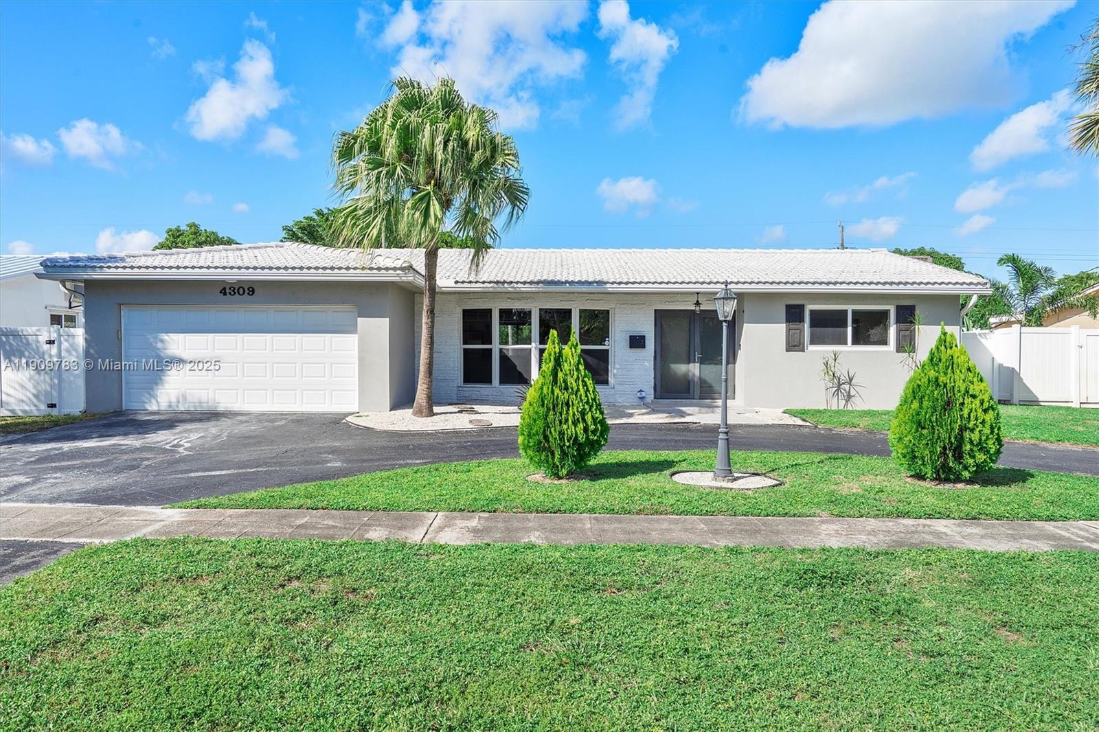 4309 Jackson Street Hollywood, FL 33021 - Photo 3 of 39 a front view of a house with a yard and garage
