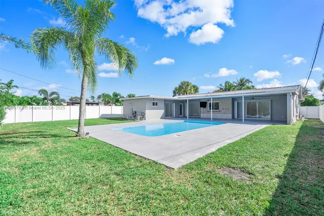a view of a house with backyard and a tree