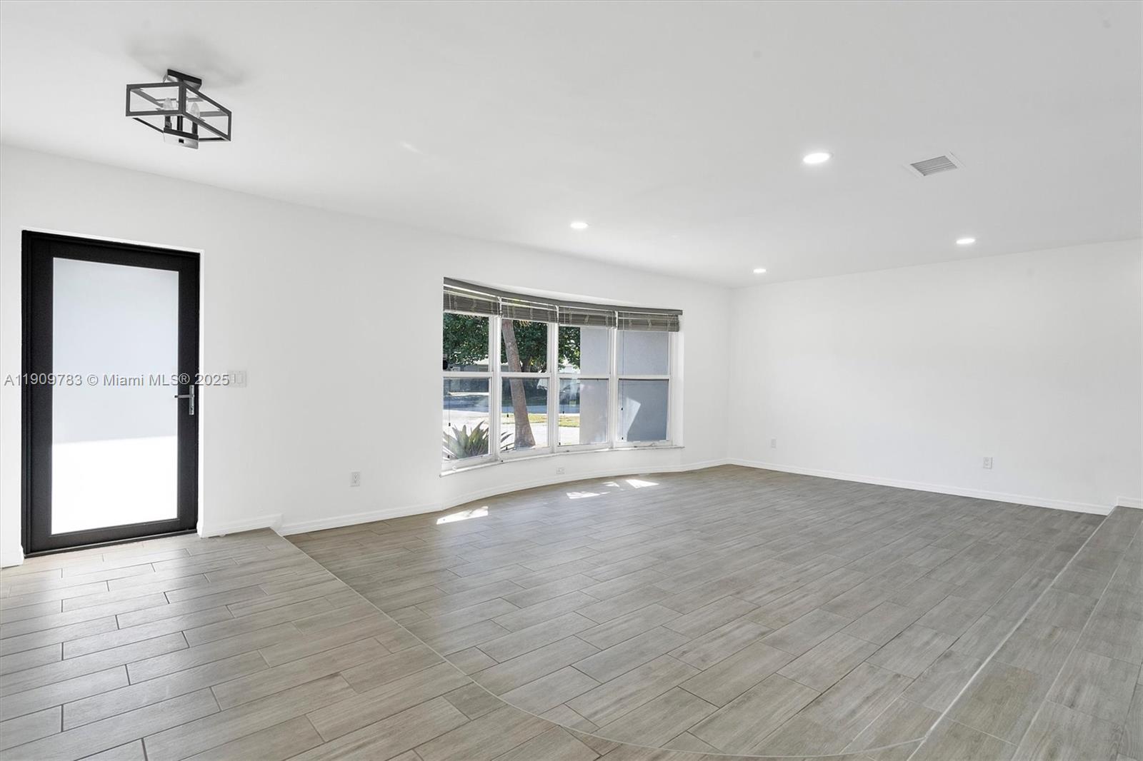 4309 Jackson Street Hollywood, FL 33021 - Photo 5 of 39 an empty room with wooden floor and windows