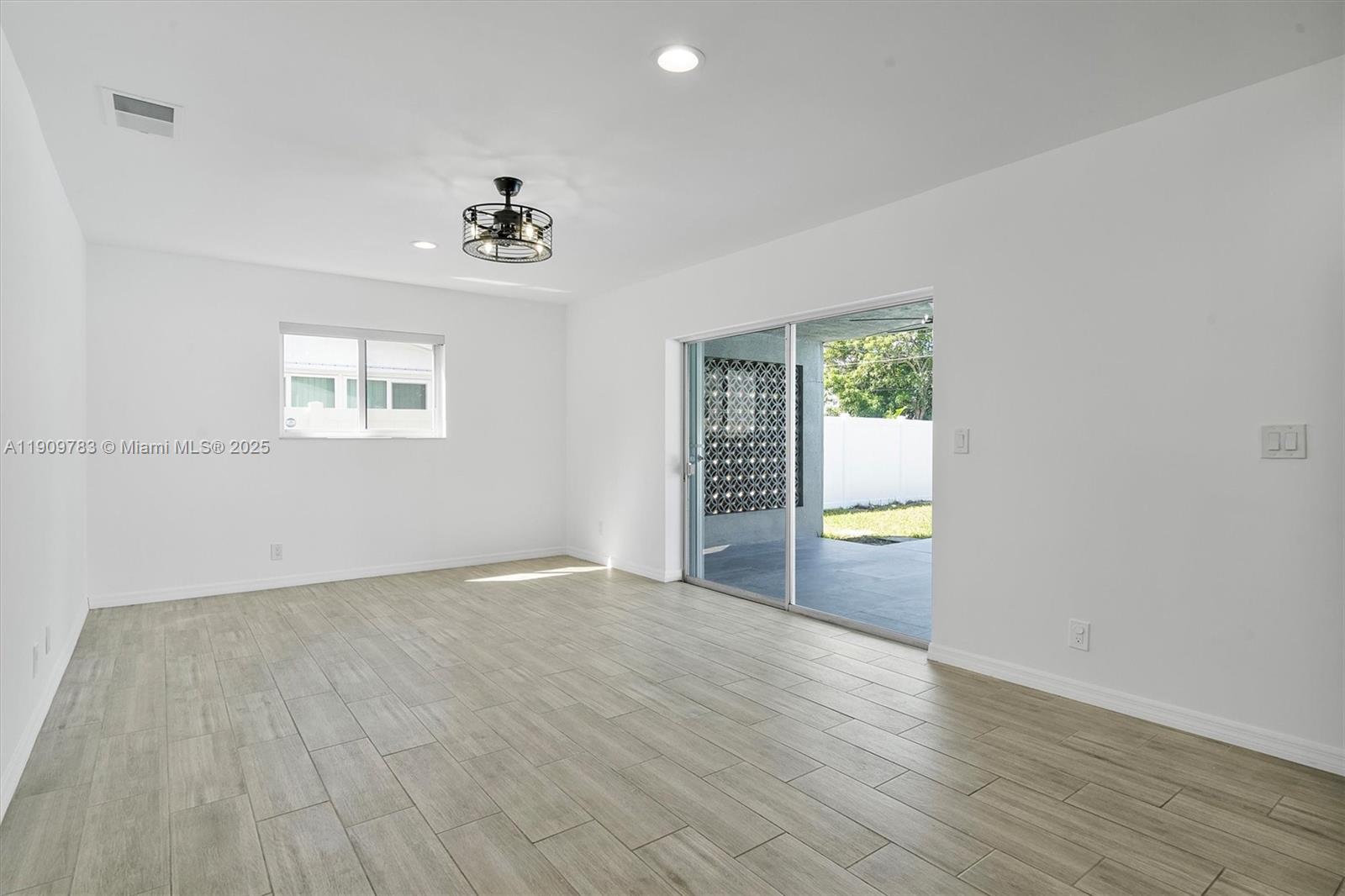 4309 Jackson Street Hollywood, FL 33021 - Photo 9 of 39 an empty room with wooden floor and windows