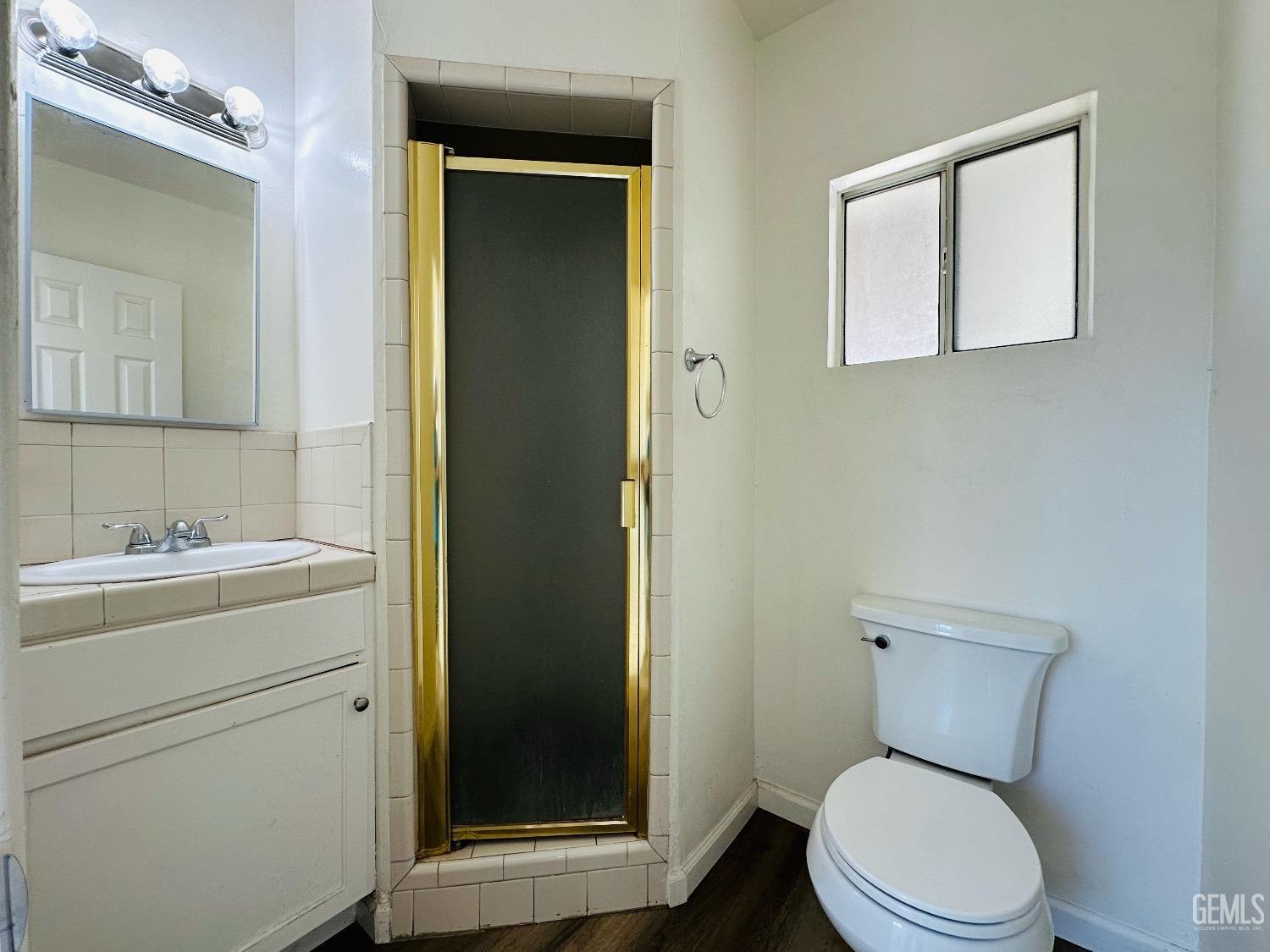 Undisclosed Address Bakersfield, CA 93304 - Photo 17 of 26 a bathroom with a toilet a sink and mirror