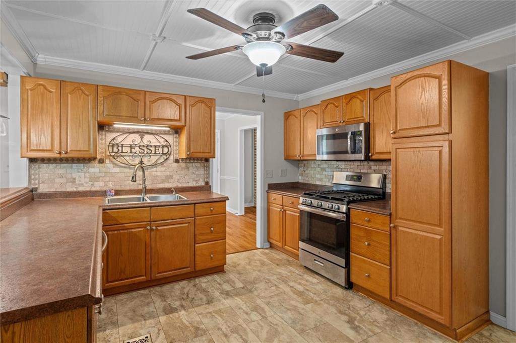 1267 Austin Bridge Road Douglasville, GA 30134 - Photo 18 of 66 a kitchen with stainless steel appliances granite countertop a stove sink and refrigerator