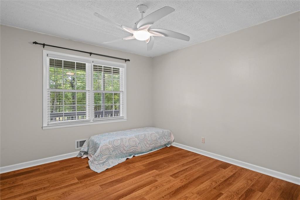 1267 Austin Bridge Road Douglasville, GA 30134 - Photo 26 of 66 a bedroom with a bed and wooden floor