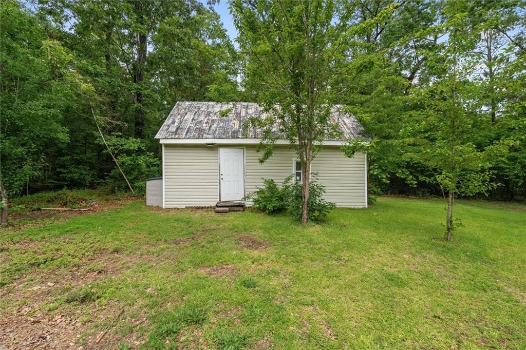 1267 Austin Bridge Road Douglasville, GA 30134 - Photo 36 of 66 a backyard of a house with plants and large tree