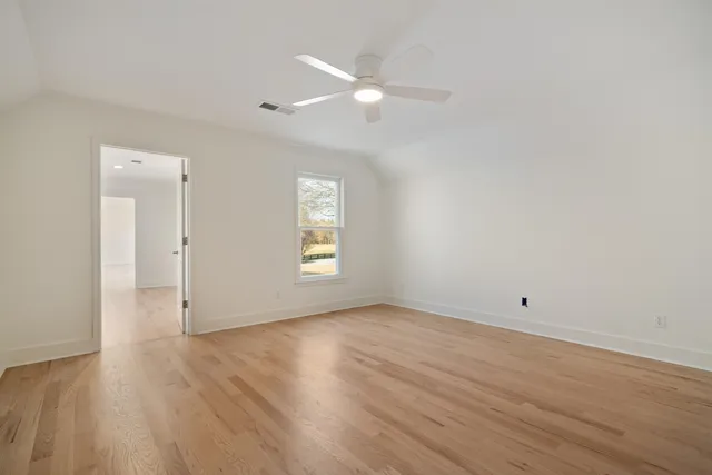 an empty room with wooden floor and white walls