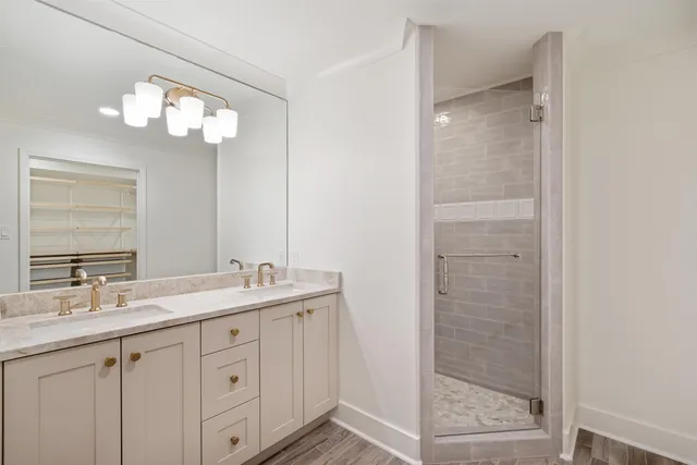 a bathroom with a double vanity sink mirror and shower