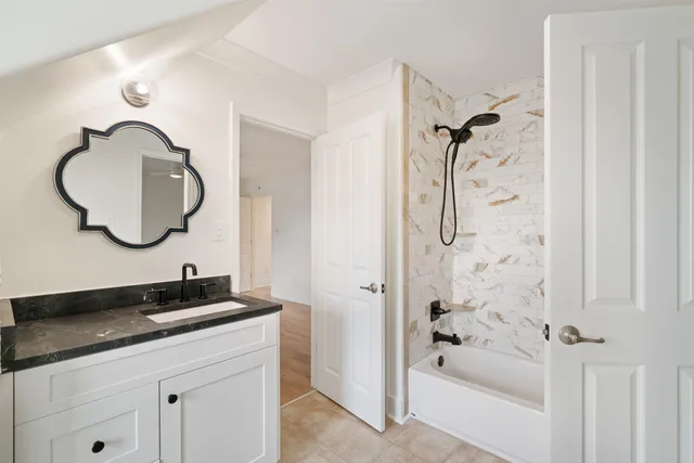 an empty room with wooden floor and fan