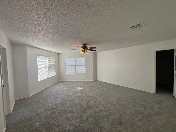 a view of a big room with windows and chandelier fan