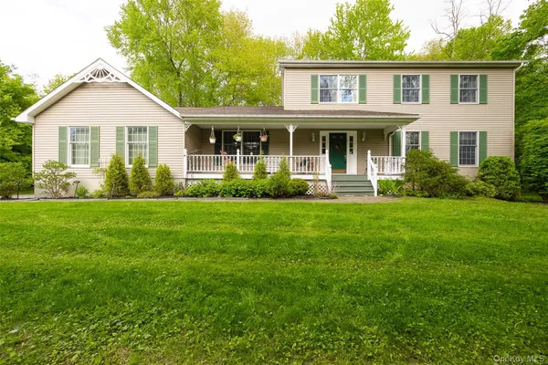 a front view of a house with a yard and green space