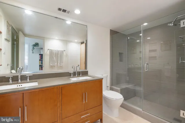 a bathroom with a granite countertop sink a toilet and shower
