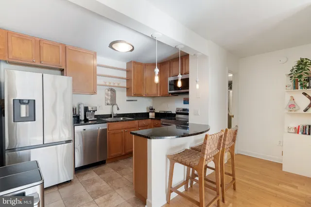 a kitchen with stainless steel appliances granite countertop a stove a sink a refrigerator a microwave and a refrigerator