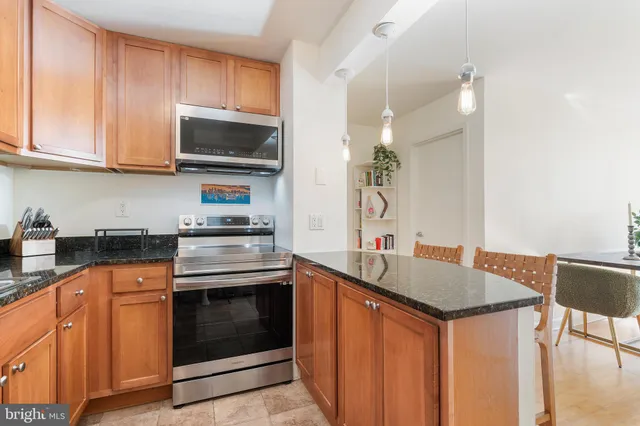 a kitchen with granite countertop a sink stove and microwave