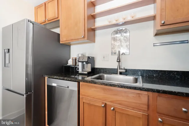 a kitchen with stainless steel appliances granite countertop a sink and a refrigerator