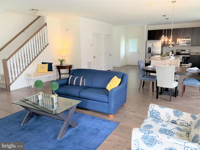 a living room with furniture a rug and a dining table