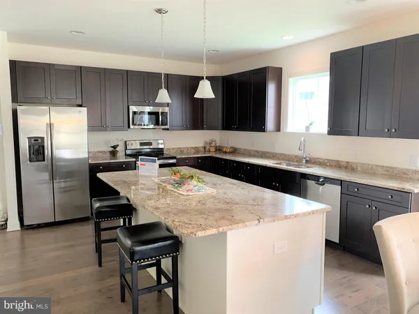 a kitchen with a sink a stove a refrigerator and a microwave