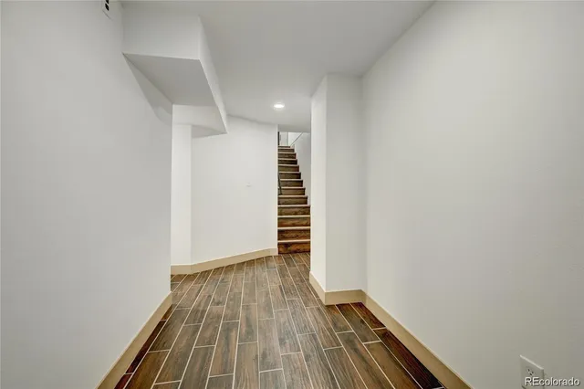 a view of hallway with stairs and wooden floor