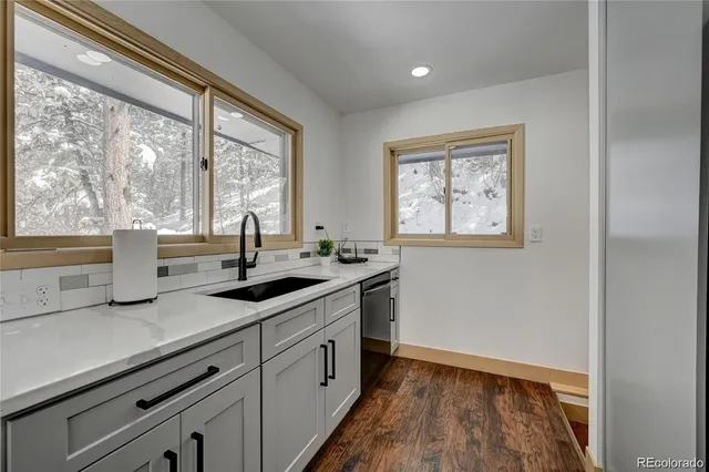 a kitchen with granite countertop a sink and wooden floor