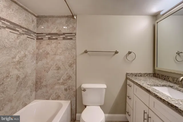 a bathroom with a granite countertop toilet sink and shower
