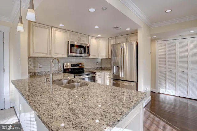 a kitchen with stainless steel appliances granite countertop a sink refrigerator and microwave