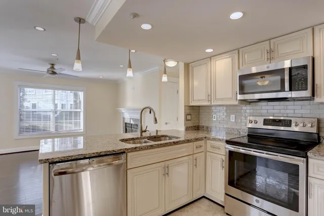 a kitchen with appliances a sink cabinets and a window