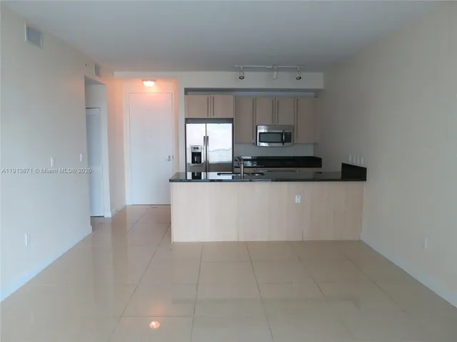 a large white kitchen with a stove a sink and dishwasher