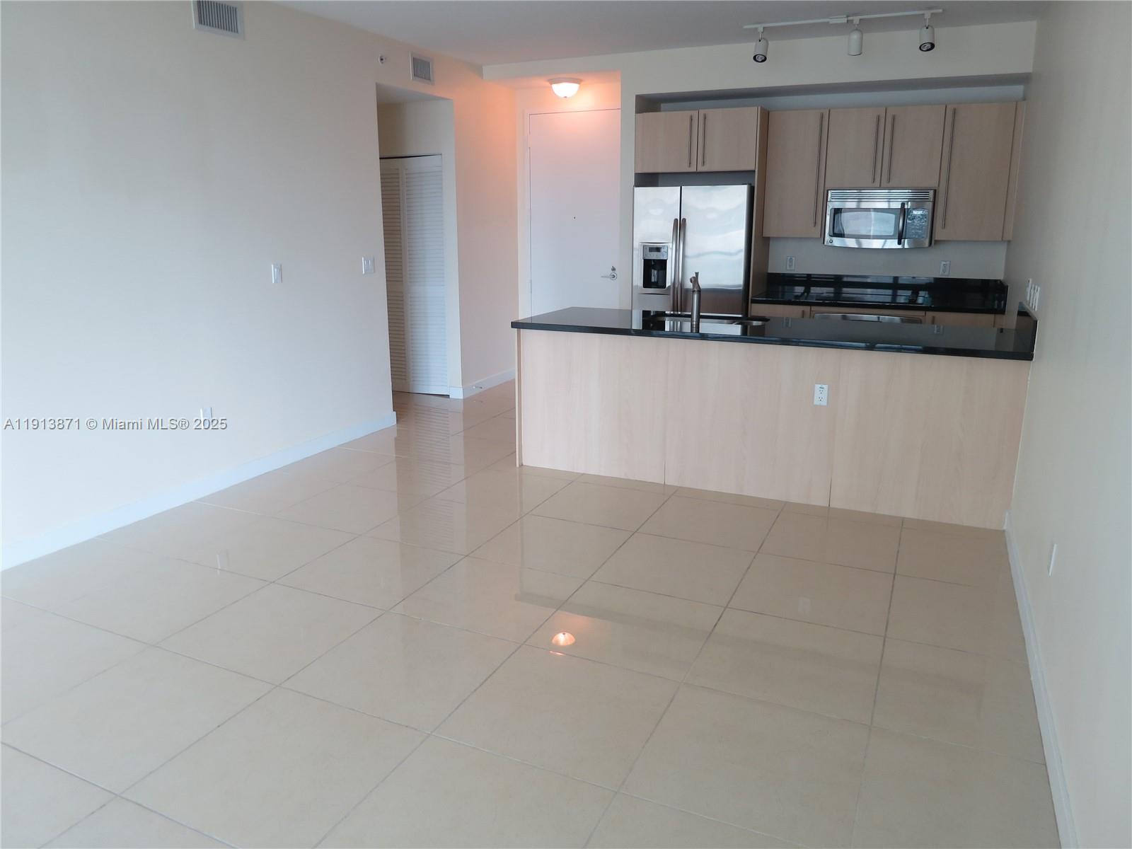 1111 Southwest 1st Avenue, Unit 1024N Miami, FL 33130 - Photo 6 of 12 a kitchen with stainless steel appliances granite countertop a sink a stove and a refrigerator