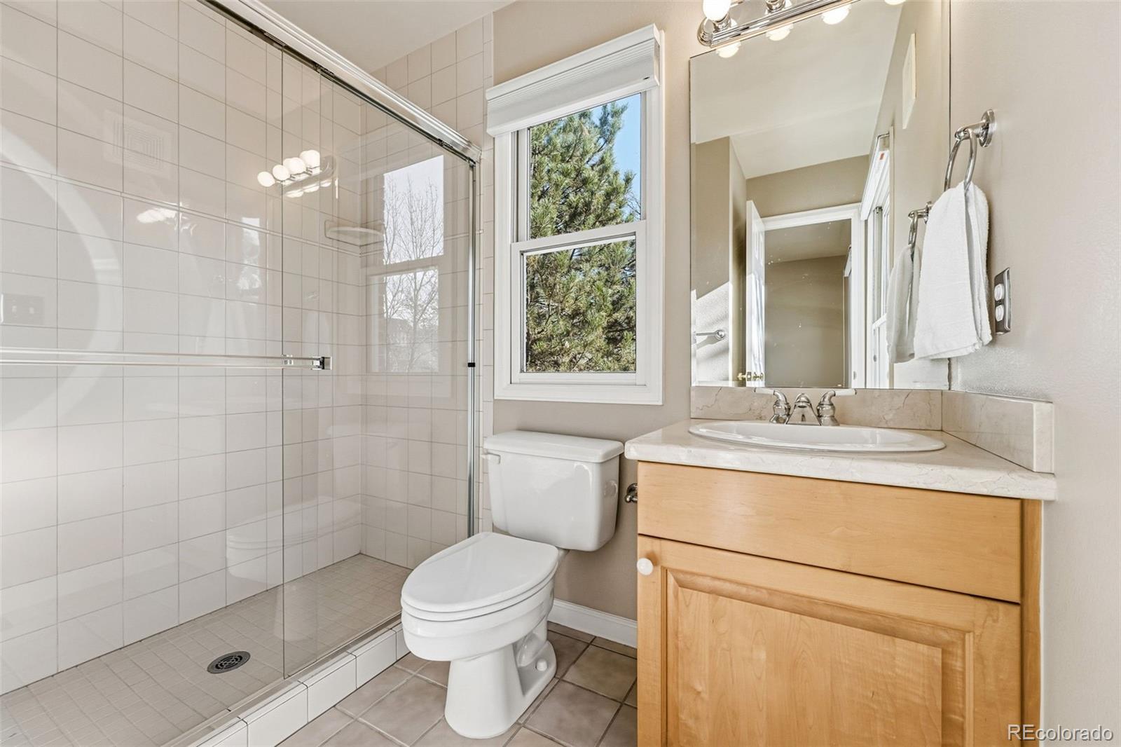 944 Ivanhoe Street Denver, CO 80220 - Photo 23 of 50 a bathroom with a granite countertop sink a toilet and shower