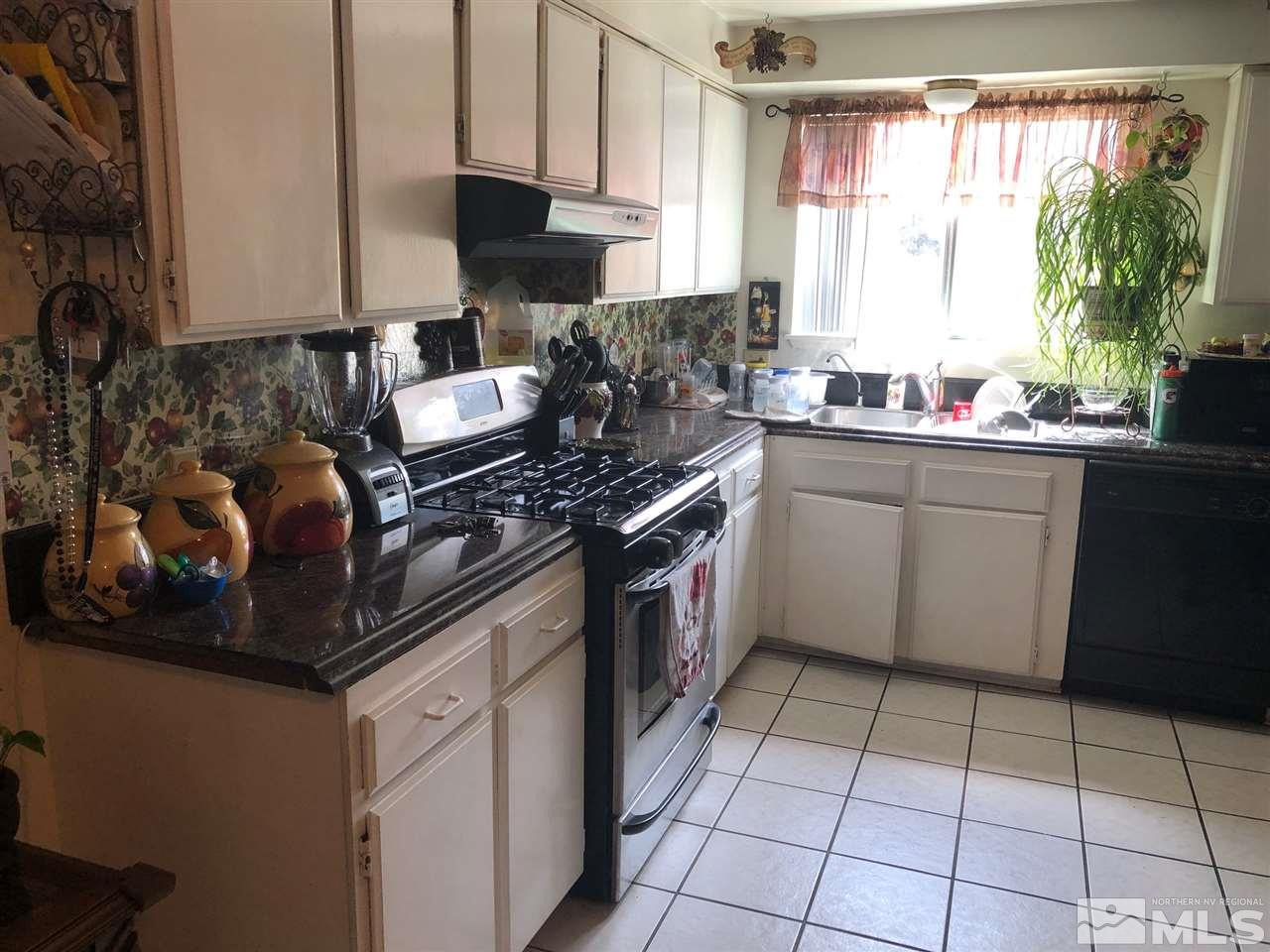 4200 Santa Maria Drive Reno, NV 89502 - Photo 4 of 14 a kitchen with stainless steel appliances granite countertop a stove a sink and a microwave