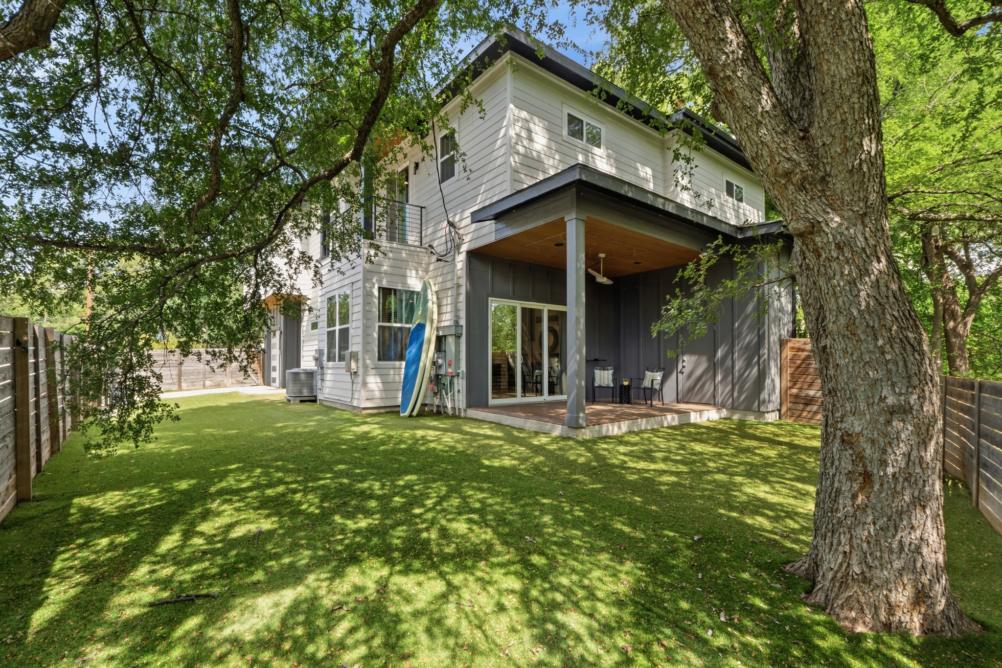 3304 East 17th Street, Unit B Austin, TX 78721 - Photo 28 of 35 A verdant turf grass lawn surrounds this modern home, offering a tranquil retreat with a shaded patio perfect for relaxation.