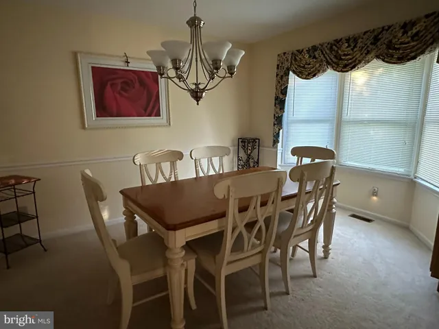 a view of a dining room with furniture and a chandelier