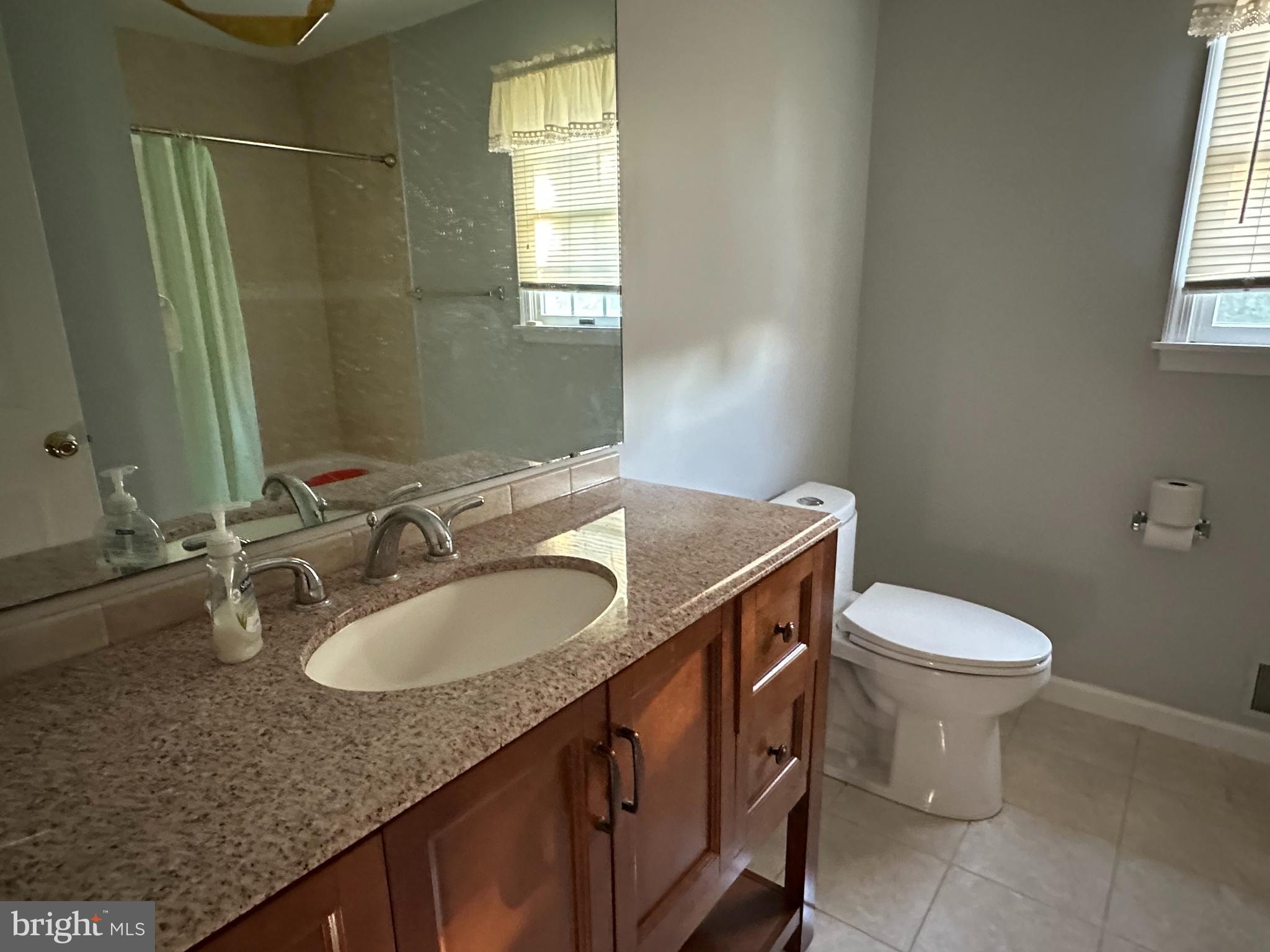 703 Lora Lane Hockessin, DE 19707 - Photo 19 of 28 a bathroom with a granite countertop sink toilet and mirror