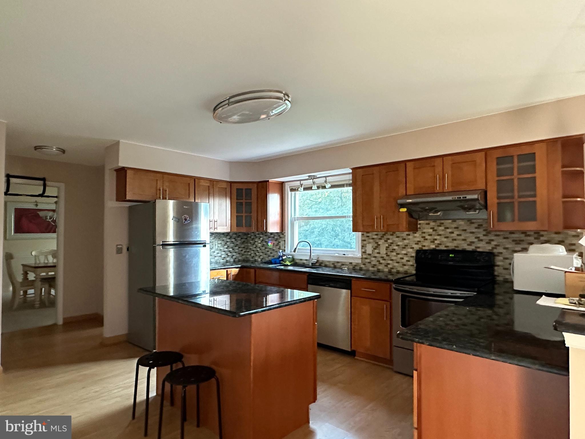 703 Lora Lane Hockessin, DE 19707 - Photo 9 of 28 a kitchen with stainless steel appliances granite countertop a sink stove and refrigerator