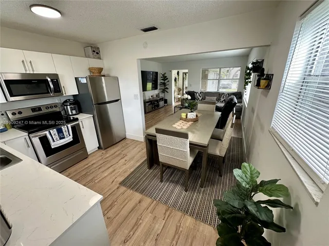 a view of a dining room with furniture a rug and wooden floor