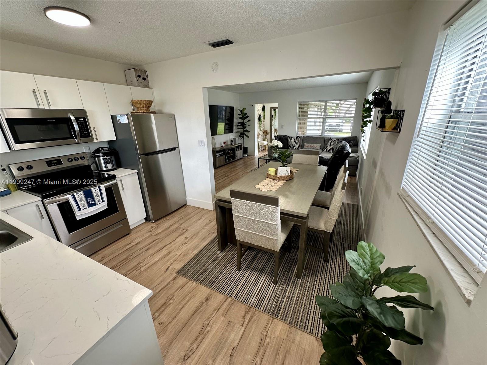 a view of a dining room with furniture a rug and wooden floor