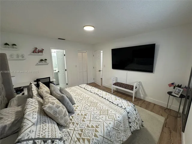 a bedroom with a bed and a flat screen tv