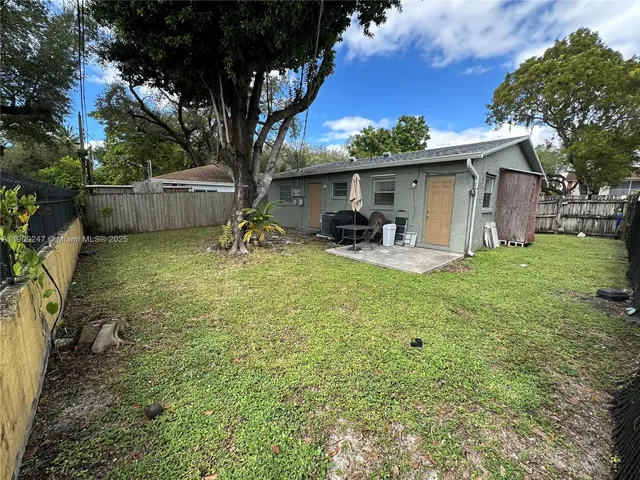 a backyard of a house with table and chairs