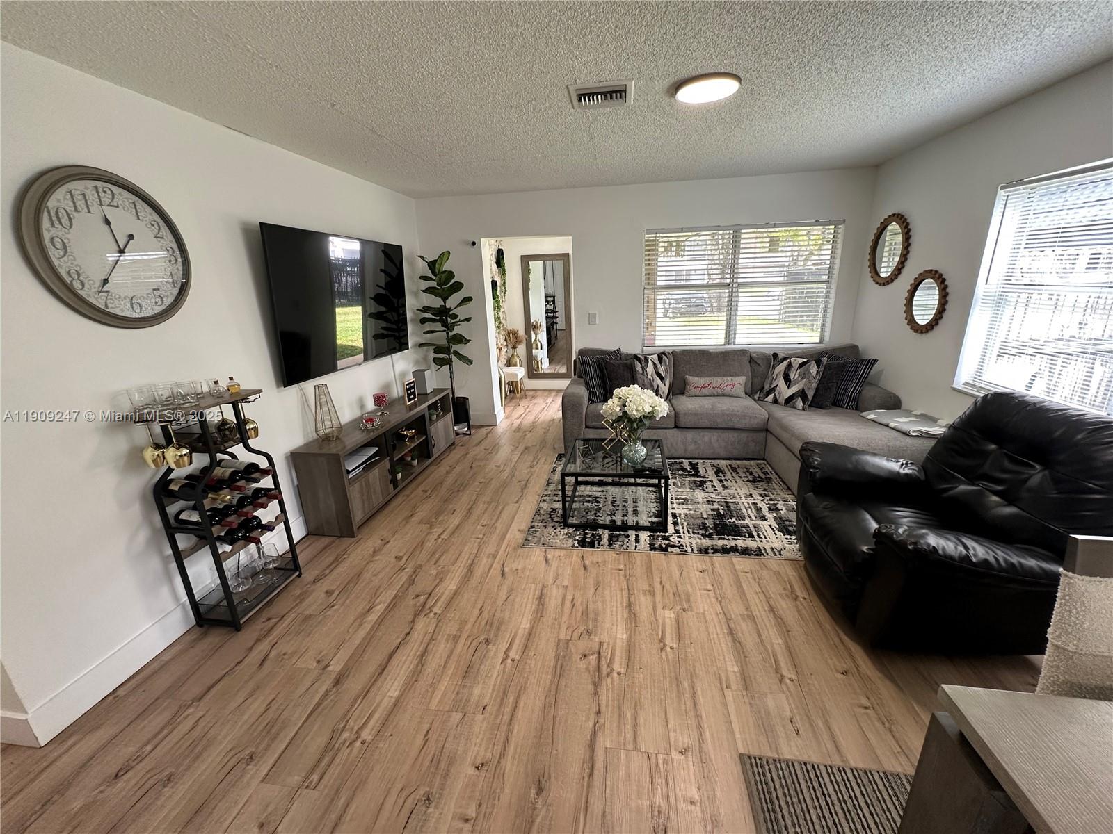 6040 Southwest 35th Street, Unit 2 Miramar, FL 33023 - Photo 2 of 14 a living room with furniture a large window and wooden floor
