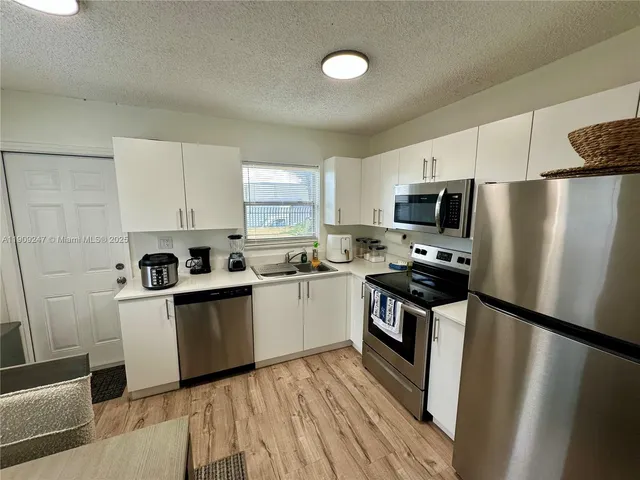 a kitchen with a refrigerator a stove top oven a sink and dishwasher