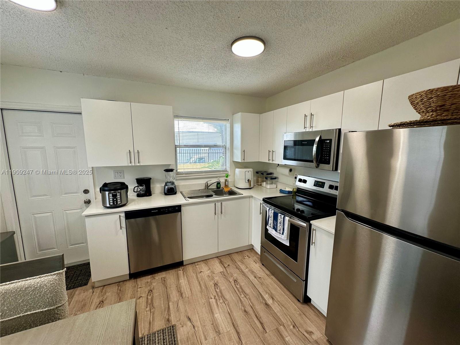 6040 Southwest 35th Street, Unit 2 Miramar, FL 33023 - Photo 8 of 14 a kitchen with a refrigerator a stove top oven a sink and dishwasher