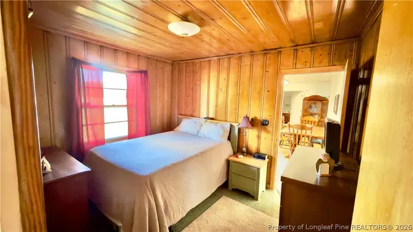 a spacious bedroom with a bed and a chandelier