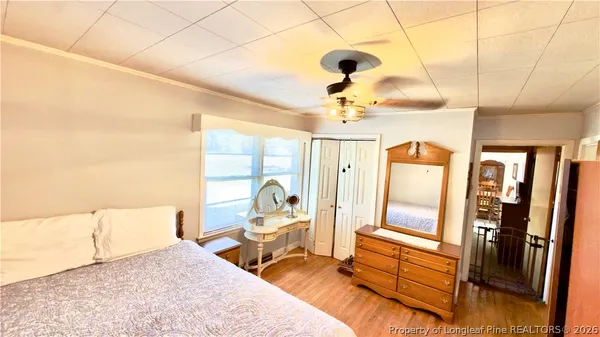 a bedroom with a bed and wooden floor