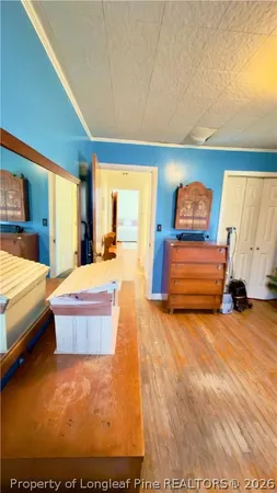a large bedroom with a bed and wooden floor