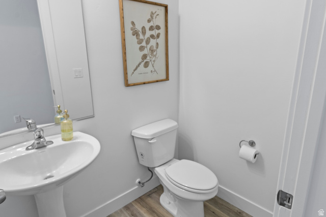 1264 West 500 South, Unit 320 Logan, UT 84321 - Photo 38 of 39 Pedestal sink with chrome faucet and white toilet set against light wood-finish flooring