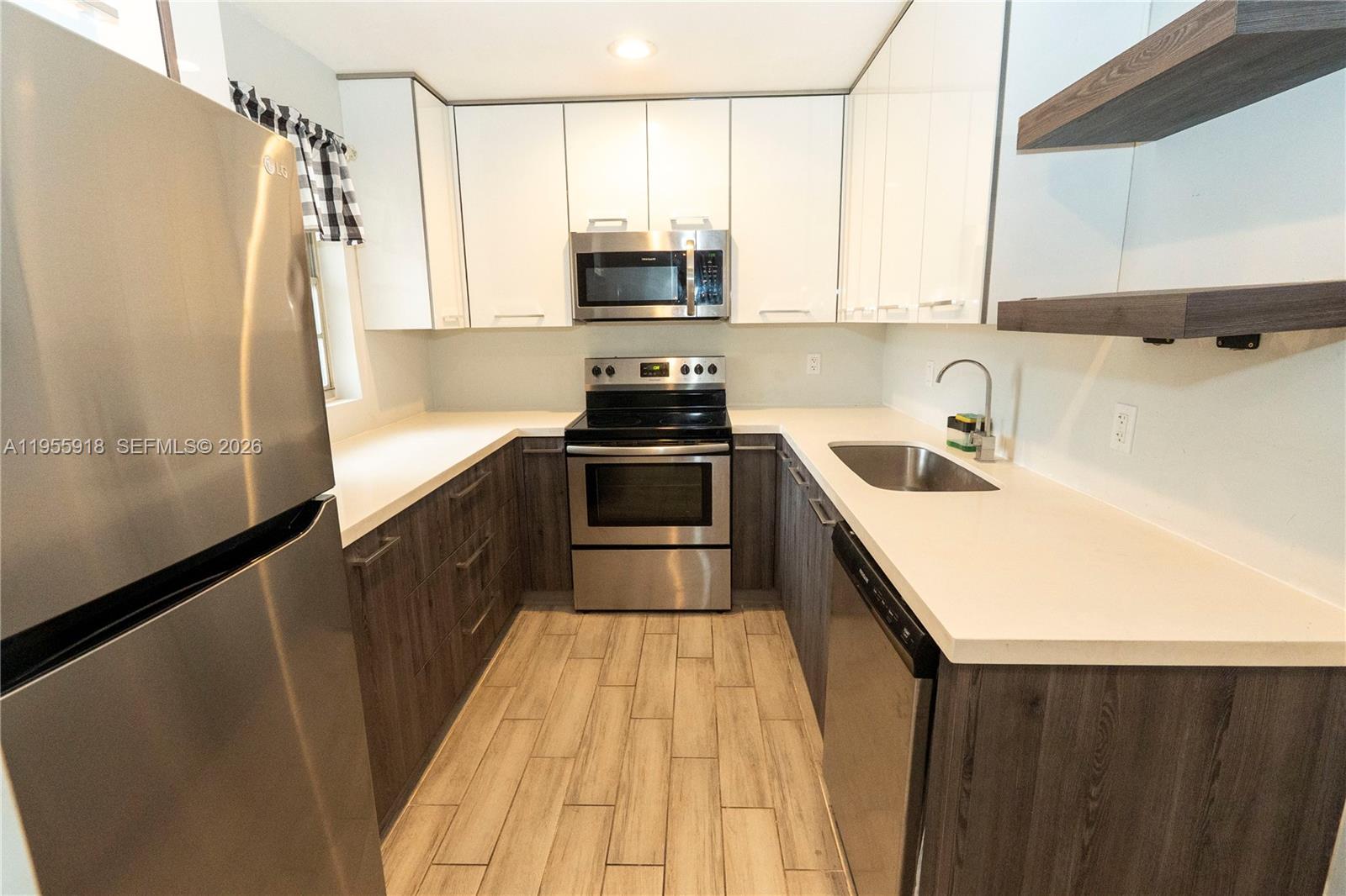 7743 Southwest 86th Street, Unit D227 Miami, FL 33143 - Photo 12 of 24 a kitchen with stainless steel appliances a sink stove and refrigerator