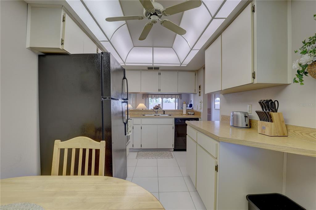 2131 Ridge Road South, Unit 132 Largo, FL 33778 - Photo 14 of 32 a kitchen with a refrigerator and cabinets