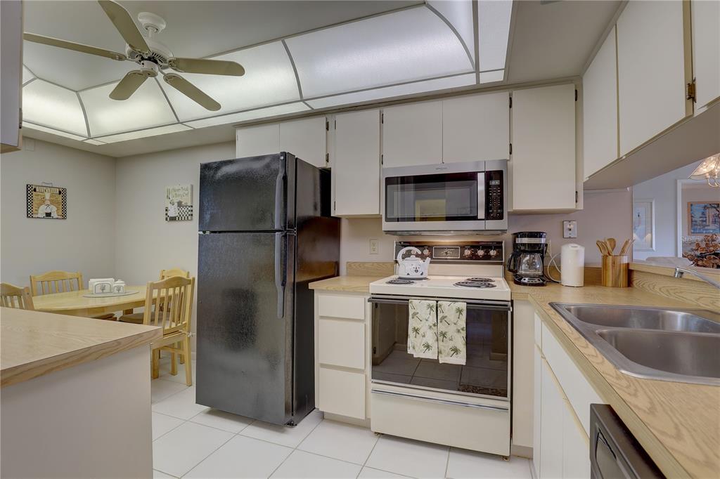 2131 Ridge Road South, Unit 132 Largo, FL 33778 - Photo 16 of 32 a kitchen with stainless steel appliances granite countertop a refrigerator a stove and a sink