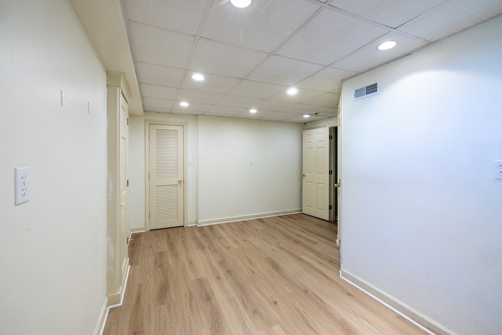 12 Pickett Street, Unit H Beverly, MA 01915 - Photo 27 of 31 an empty room with wooden floor and windows