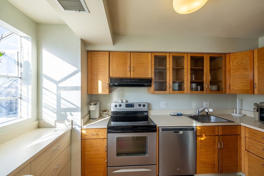 12 Pickett Street, Unit H Beverly, MA 01915 - Photo 5 of 31 a kitchen with a stove a sink and a microwave