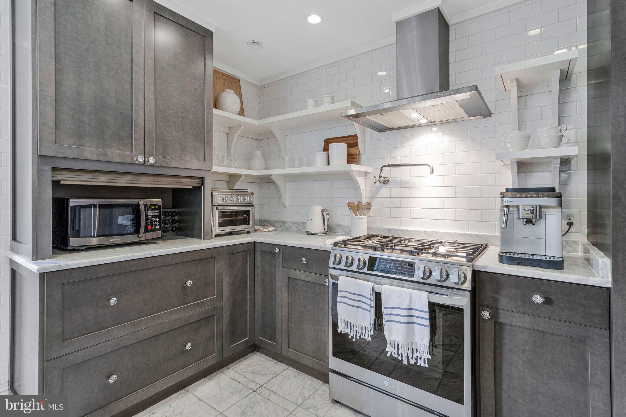 611 G Street Southeast Washington, DC 20003 - Photo 12 of 32 a kitchen with stainless steel appliances granite countertop a stove and a wooden cabinets