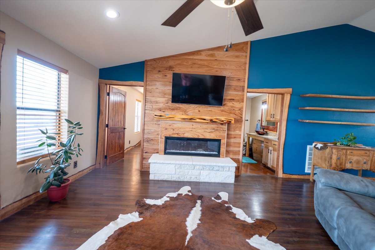 1825 Savanna Ridge Ranch Road Lometa, TX 76853 - Photo 6 of 35 Living area with vaulted ceiling, wood finished floors, a ceiling fan, and a stone fireplace